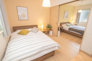 Uma cama ou camas num quarto em Ecru Haruyoshi Logement