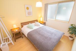 Uma cama ou camas num quarto em Ecru Haruyoshi Logement