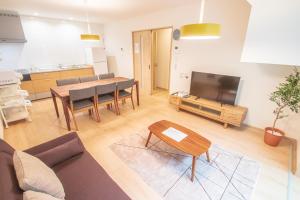 Uma televisão e/ou sistema de entretenimento em Ecru Haruyoshi Logement