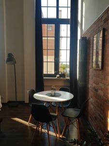 a table and chairs in a room with a brick wall at LOFT 314 in Żyrardów