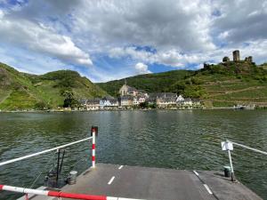 a boat on a lake with a castle on a hill at Haus von Hoegen in Cochem