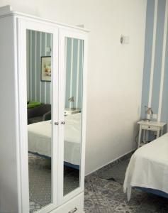 een spiegel in een kamer met een bed en een slaapkamer bij Door Eight in Il-Furjana
