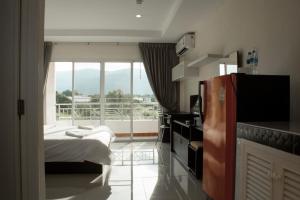 a hotel room with a bed and a large window at Nattidaplace Hotel Chiangmai in Chiang Mai
