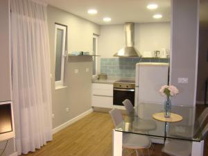 eine Küche mit einem Glastisch und einem Kühlschrank in der Unterkunft Apartamentos La Pereda Santander- Estudio E1 in Santander