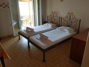 two beds sitting in a room with a window at Filippos Apartments "Apartment 2" in Spartia