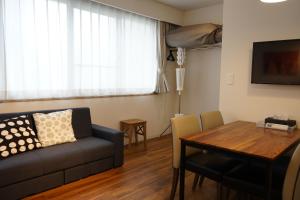 uma sala de estar com um sofá e uma mesa em Culinary Bed&Art 404 em Hamamatsu