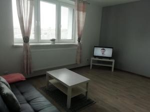 a living room with a couch and a tv at Apartmány Stdaniela in Bohumín