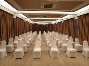 サッタヒープにあるSwan Lake Hotel Sattahipの白い椅子とカーテンのある会議室