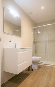 ein weißes Bad mit einem Waschbecken und einem WC in der Unterkunft Apartamentos LA PEREDA SANTANDER in Santander