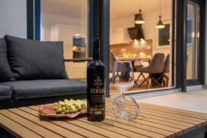 a bottle of wine and a glass on a table at Villa Manhattan in Dobrinj