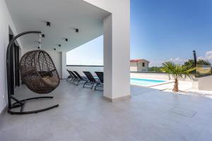 a living room with a swing and a swimming pool at Villa Manhattan in Dobrinj