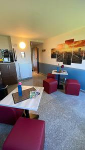 a living room with red chairs and a table at Motel 44 in Geseke