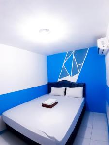 a blue and white bedroom with a large bed at Hotel Olympic Jogyakarta by Sajiwa in Yogyakarta