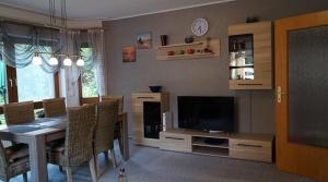 a living room with a dining table and a television at Ferienwohnung Familie Neugebauer in Bruchhausen-Vilsen