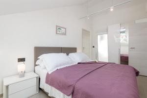 a bedroom with a bed with a purple blanket at Apartments Marando in Dubrovnik