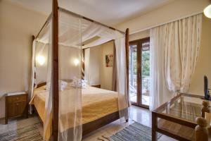 a bedroom with a canopy bed and a window at MEGA AMMOS HOTEL in Syvota +29 photos