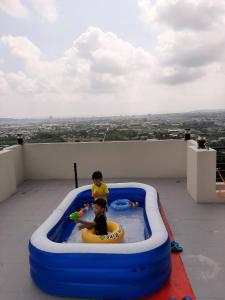 吉安的住宿－藍山會館，两名儿童在阳台上的充气游泳池玩耍