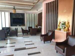 a lobby with a waiting area with chairs and tables at Swan Lake Hotel Sattahip in Sattahip