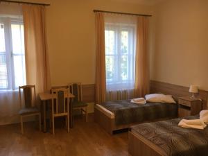 クリニツァ・ズドルイにあるStary Dom Zdrojowyのベッドルーム1室(ベッド2台、テーブル、椅子付)