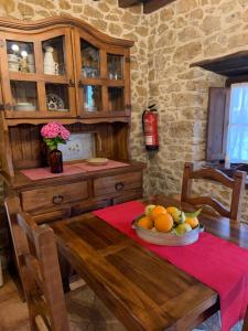 una cocina con una mesa de madera y un bol de fruta en Na’bolera, en Nava