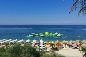 a beach with a water park with slides and umbrellas at close to the beach in Athens