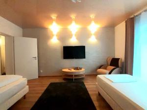 uma sala de estar com um sofá e uma televisão em Modernes Apartment Metzingen 2 em Reutlingen