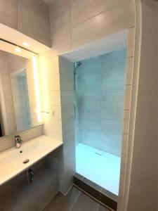 uma casa de banho com um chuveiro, um lavatório e um espelho. em Modernes Apartment Metzingen 2 em Reutlingen