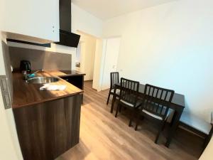 a kitchen with a sink and a table with chairs at Modernes Apartment Metzingen 2 in Reutlingen
