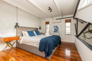 a bedroom with a bed with blue pillows at StayCentral - Fitzroy Converted Warehouse Penthouse in Melbourne