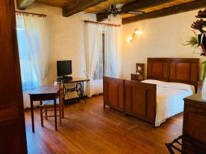 Schlafzimmer mit einem Bett, einem Schreibtisch und einem TV in der Unterkunft Agriturismo Cascina Smeralda in Pontestura