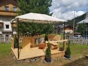 a pavilion with an umbrella in a yard at Blizzard apartments in Arabba