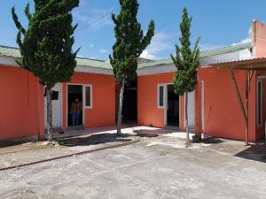 an orange house with trees in front of it at QQ HOMESTAY in Takengon