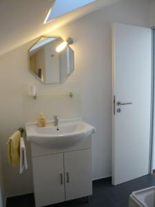 a bathroom with a white sink and a mirror at Am Moos in Isny im Allgäu