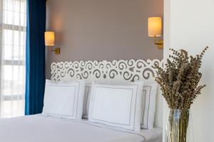 a white bed with two pillows and a vase with flowers at Petros Hotel in Istanbul