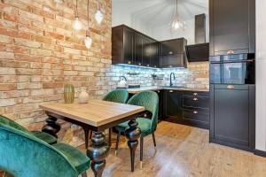 a kitchen with a wooden table and green chairs at GRANO APARTMENTS Gdańsk Old Town SPA & Wellness in Gdańsk