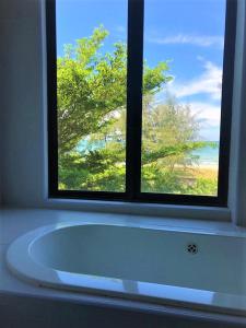 a bath tub in a bathroom with a window at Samsuria Private Beach Front in Kuantan