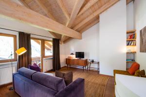 a living room with a blue couch and wooden ceilings at Apartment Stifter in Lutago