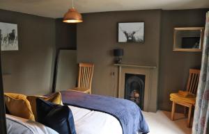a bedroom with a bed and a fireplace at Culm Valley Inn in Culmstock