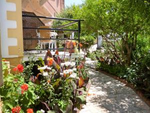 un jardín con flores y un paseo en Kostas studios en Agios Georgios Pagon