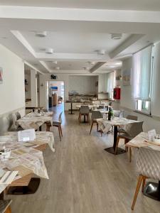 um restaurante com mesas e cadeiras num quarto em Albergo Villa Aida em Riccione