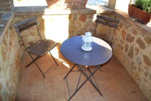 einen Tisch und zwei Stühle auf einer Terrasse in der Unterkunft Agriturismo Il Casalino in Pienza