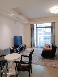 ein Wohnzimmer mit einem Tisch und Stühlen sowie einem TV in der Unterkunft 一中太陽綠墅 in Taichung