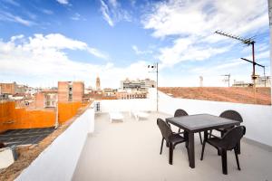 a patio with a table and chairs on a roof at Design Club Reus in Reus