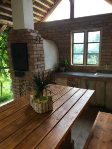 a large wooden table in a room with windows at Miklós Lak in Ocna de Sus