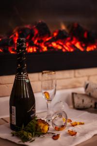 una botella de vino y copas en una mesa con chimenea en "Отель 24 часа", en Barnaul