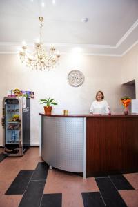 Una mujer está parada en un mostrador en una cocina en "Отель 24 часа", en Barnaul