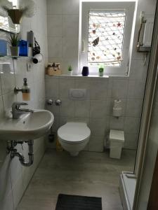 ヴィンターベルクにあるFewo Celinaのバスルーム(トイレ、洗面台付)、窓が備わります。
