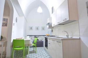 una cucina con tavolo e sedie verdi in una stanza di Lu Trisciulu a Castrignano del Capo