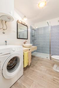 een badkamer met een wasmachine en een wastafel bij Casa Bepi in Kanfanar