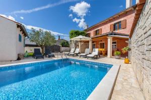 a swimming pool in a yard with a house at Casa Bepi in Kanfanar